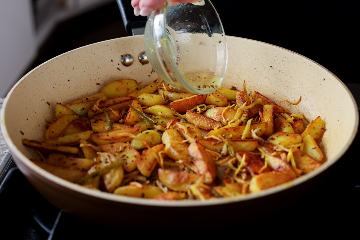 adding vinegar to Nepali aloo
