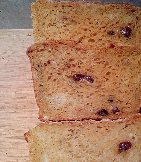 Slices of Carrot Ginger Raisin Bread on a wooden cutting board