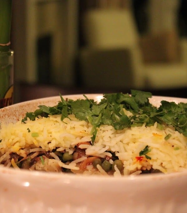 A 3 layer garlicky veg biryani in a deep white bowl