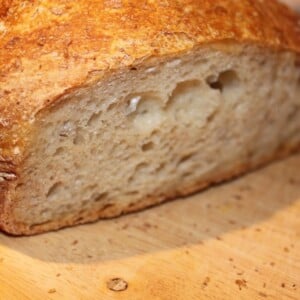 No knead bread sliced in half on a wooden work surface