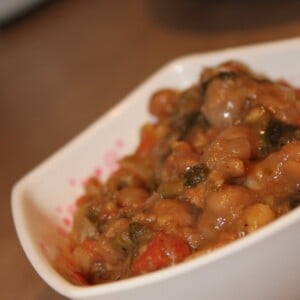 Palak Chole (spinach curry) in a white bowl on a wooden work surface