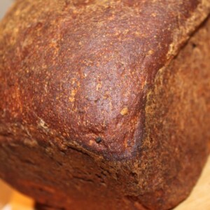 a loaf of flax seed bread on a wooden surface