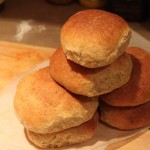 A stack of orange buns on a wooden work surface