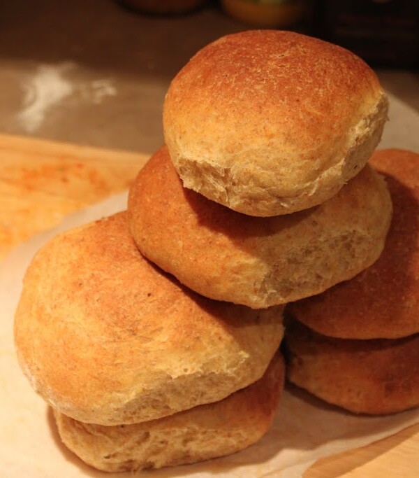 A stack of orange buns on a wooden work surface