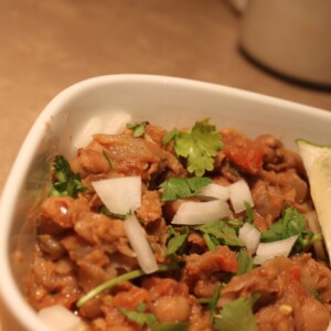 A bowl of everyday chole with a wedge of lemon