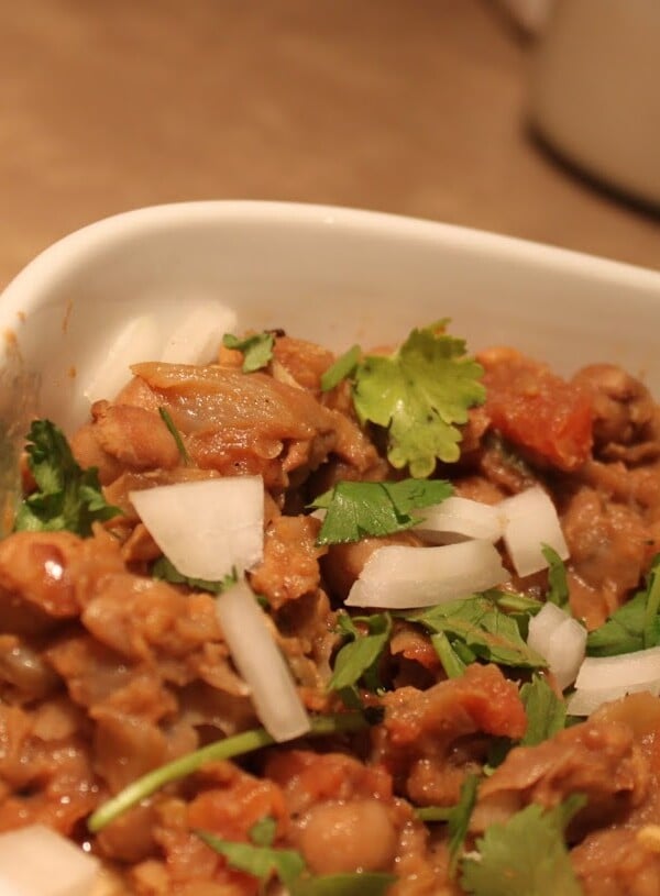 A bowl of everyday chole with a wedge of lemon