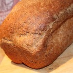 A Strawberry lemon flax seed bread loaf on a wooden cutting board