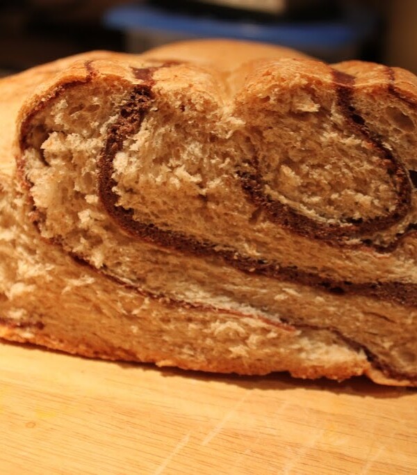 A loaf of chocolate swirl bread cut in half on a work surface