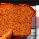 A slice of bread being held up towards camera