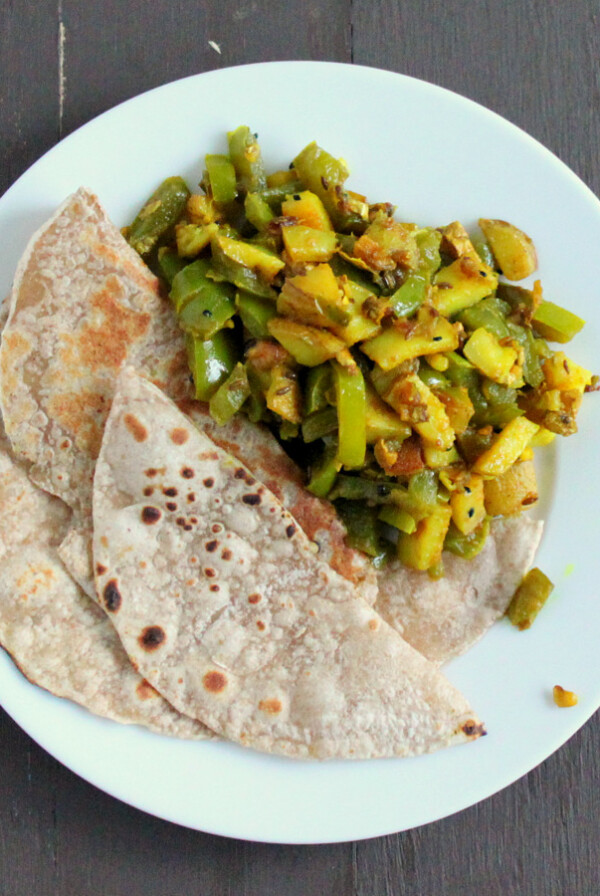 Saunf Aur Kalonji Waale Aloo Shimla Mirch served on a white plate with roti