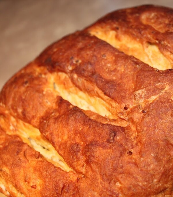 A loaf of mango cardamom raisin multigrain bread on a wooden work surface