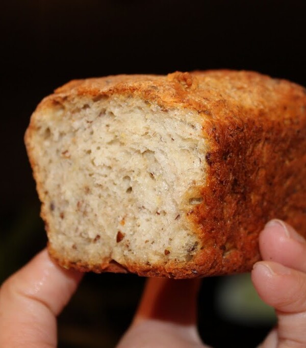A pumpkin pie spiced oats and quinoa mini loaf being held towards the camera