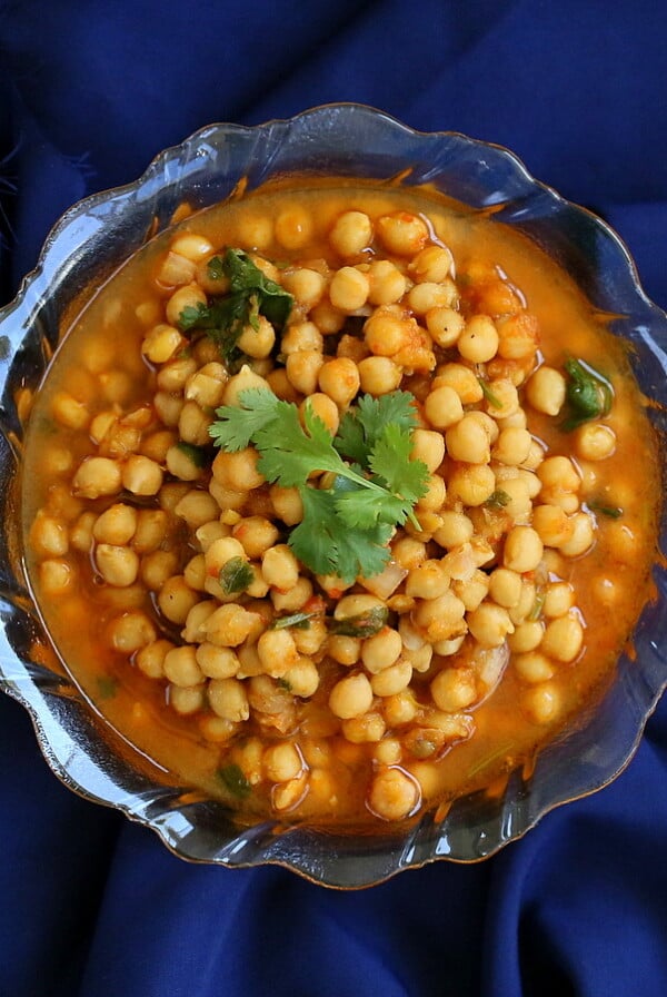 Imli chole served in a bowl on a dark blue background