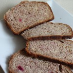 Slices of beet and strawberry wheat loaf spread out on a white plate