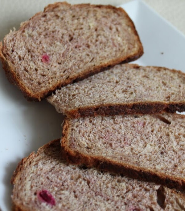 Slices of beet and strawberry wheat loaf spread out on a white plate