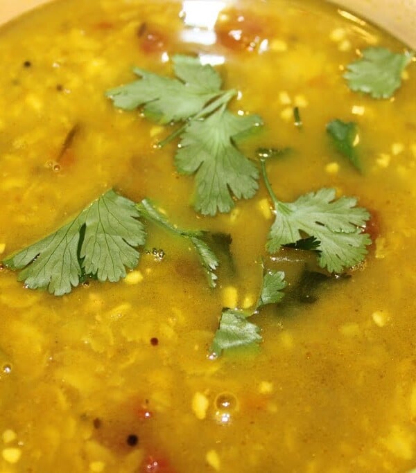 A close up of teen daal tadka garnished with cilantro