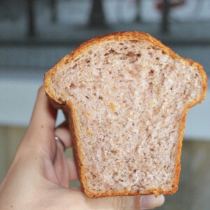 A slice of strawberry orange mini loaf held up to the camera
