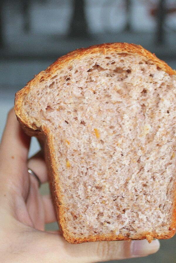 A slice of strawberry orange mini loaf held up to the camera
