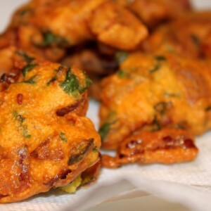 Onion fritters lying on some white parchment paper