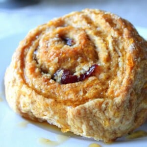 A carrot cake sticky roll on a blue plate