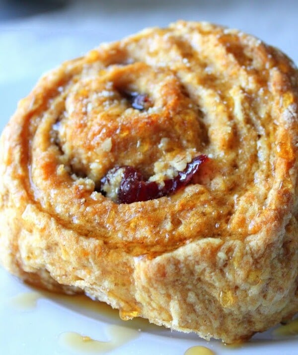 A carrot cake sticky roll on a blue plate