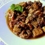 Fake chicken curry served on a white plate with a green garnish