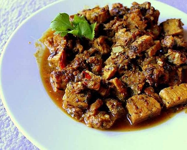 Fake chicken curry served on a white plate with a green garnish