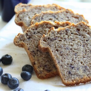 Slices of Multigrain Multifruit Mini Loaf on a white plate with some blueberries