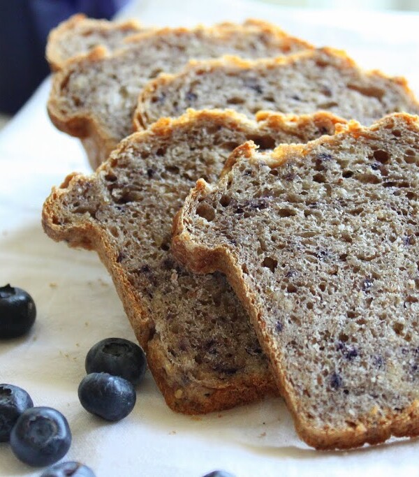 Slices of Multigrain Multifruit Mini Loaf on a white plate with some blueberries