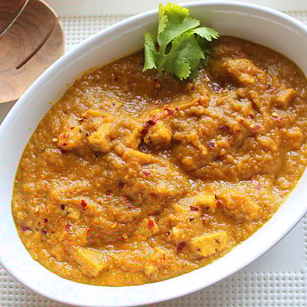 Mango curry tempeh in a white serving bowl