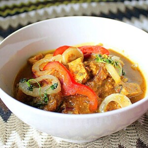 Tempeh Do Pyaaza served in a white bowl on a fabric background