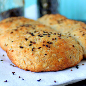White burger buns topped with seeds on a white plate