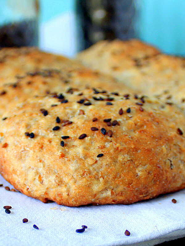 White burger buns topped with seeds on a white plate