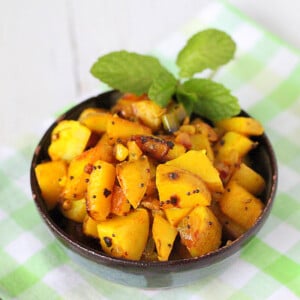 Potatoes with whole indian spices served in a bowl with cilantro garnish
