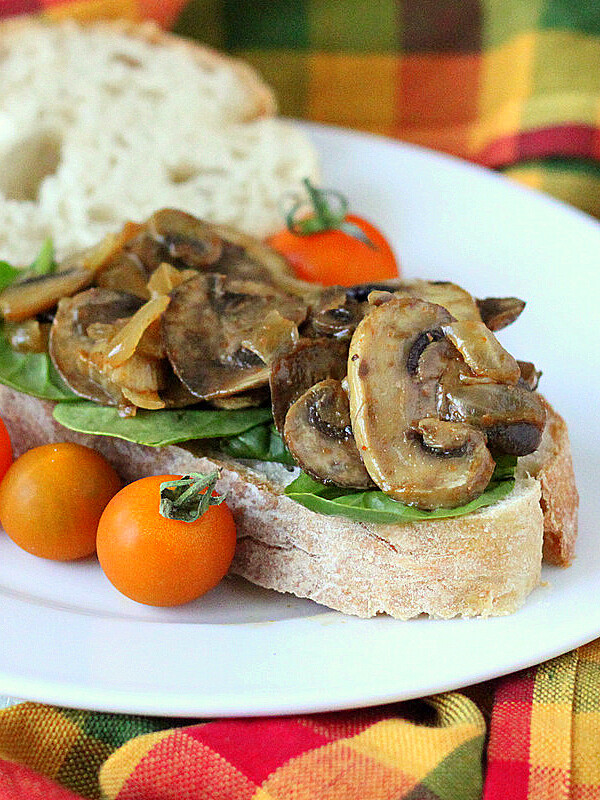 Mushroom onion saute on thick bread with a tomato garnish