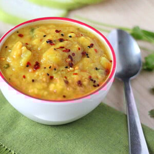 Pigeon pea soup in a white bowl on a green tablecloth