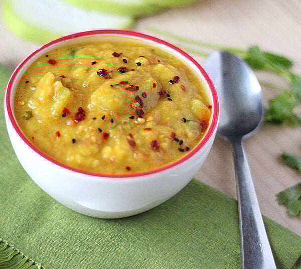 Pigeon pea soup in a white bowl on a green tablecloth