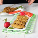 Tempeh Seekh Kebabs on a white serving plate with vegetable garnishes