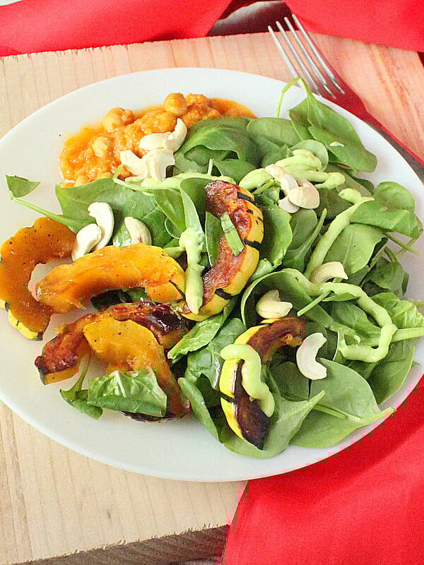 Maple Glazed Delicata Squash served on a white plate with salad