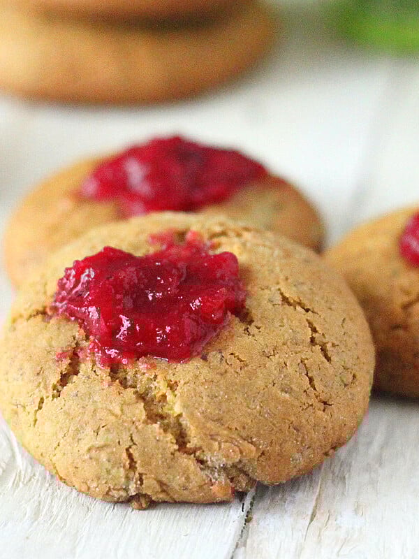 Cranberry thumbprint cookies on a wooden work surface