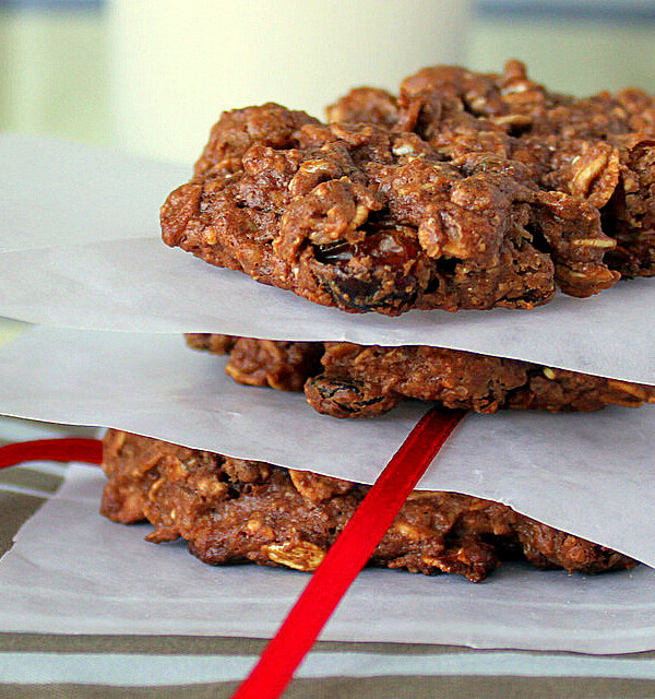 A stack of chocolate oatmeal raisin cookies separated by parchment paper