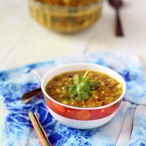 Mung bean daal soup served in a white and red bowl