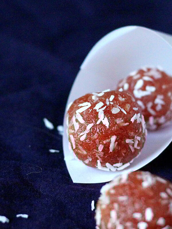 Pink coconut balls in a paper funnel on a dark background