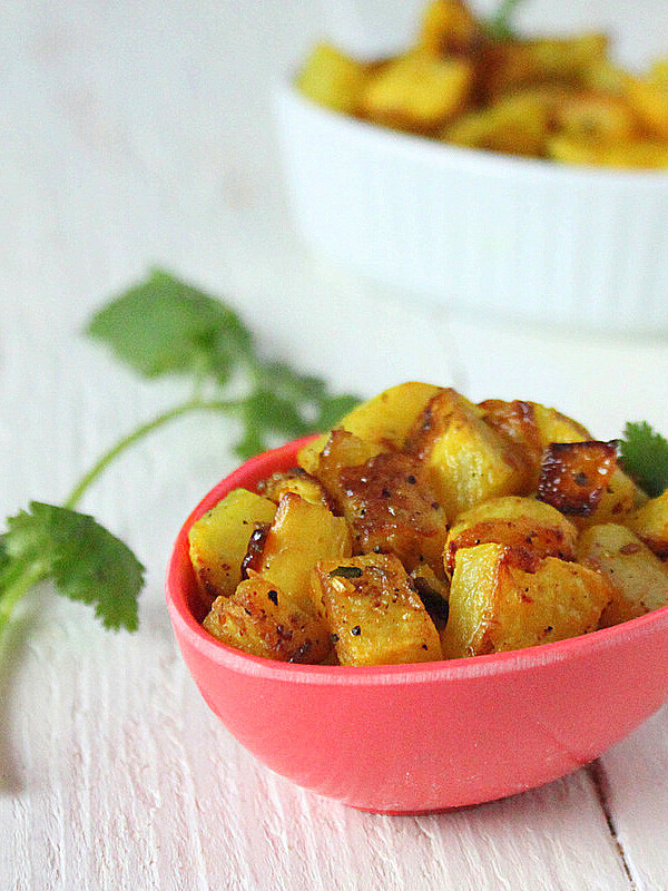Panch Phoran served in a small pink bowl with cilantro garnish