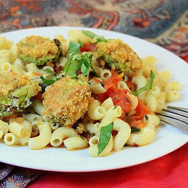 Breaded Brussels sprouts served on top of a plate of pasta