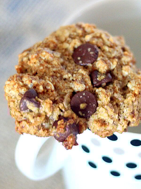 Oatmeal chocolate chip cookie resting on a mug
