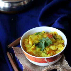 A yellow lentil stew in a bowl on a dark blue background
