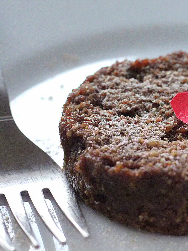 A closeup of chocolate cake on a white plate with a fork