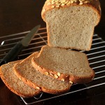 A loaf of everyday sandwich bread cut into slices on a cooling rack
