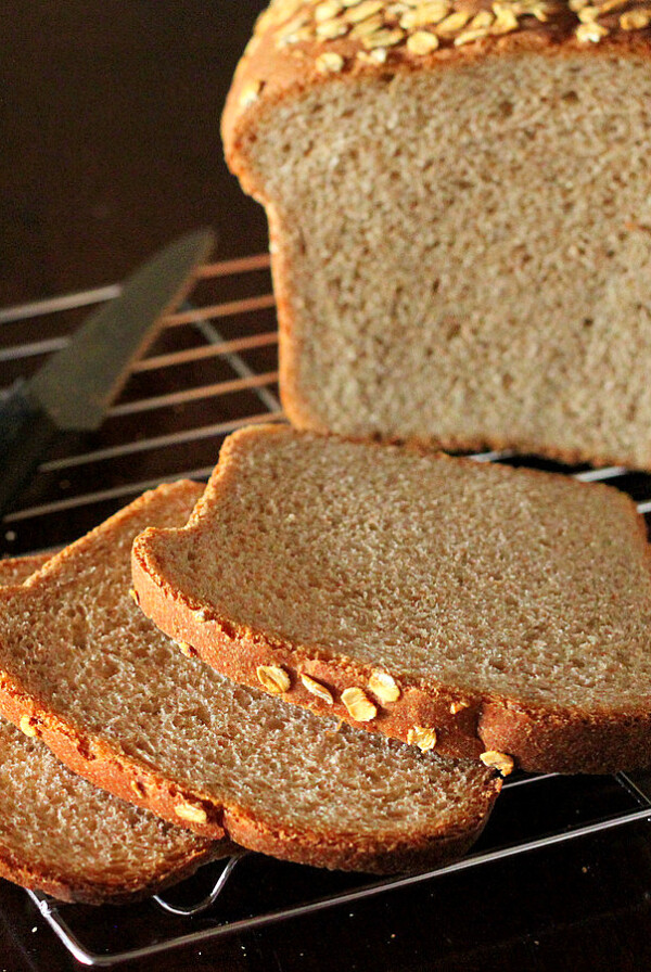 A loaf of everyday sandwich bread cut into slices on a cooling rack